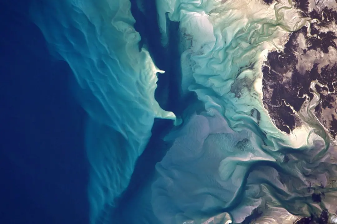 Turquoise reef shallows and ocean channels seen from the ISS — patterns of the natural world (NASA / Jeff Williams)