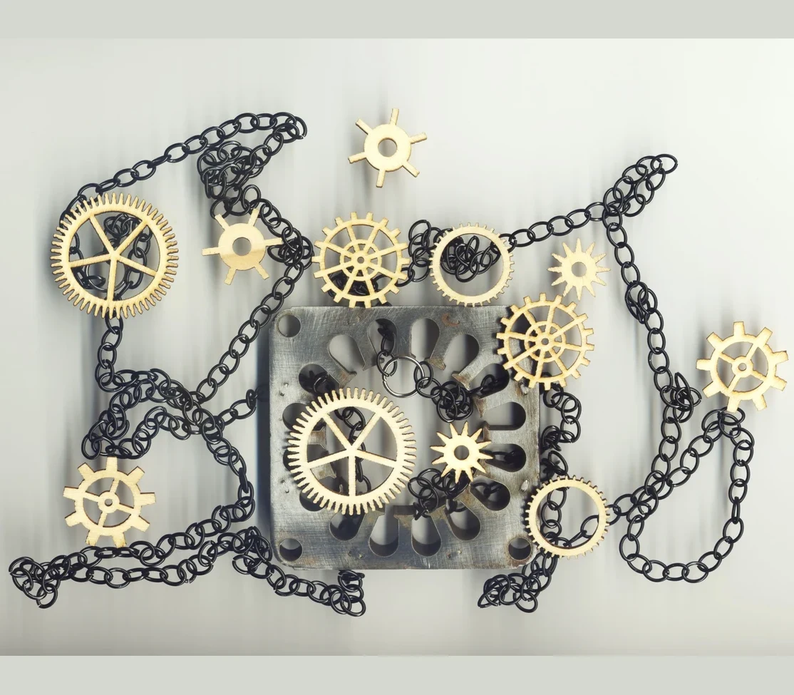 Interlocking gold gears and chains — the complex reality